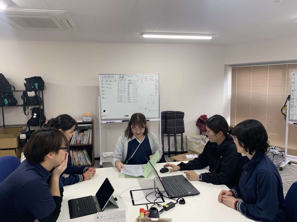 事務所で机を囲むスタッフ